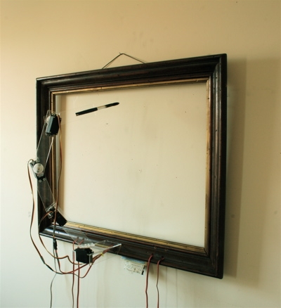 The Interactive Drawing Arm mid-drawing, ink brush sweeping across a paper canvas inside a wood frame.