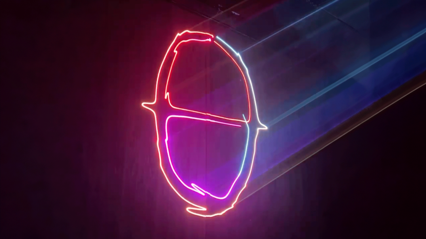 The Godmode logo projected onto a wall with neon lasers.