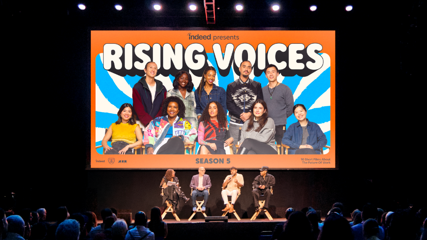 Rising Voices Season 5 filmmakers on stage with vibrant sunburst graphic design featuring bubbly typography